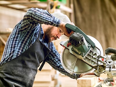 Man Operating Construction Power Saws & Tools